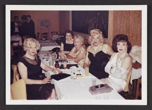 [Anita, Gloria, and friends around a table with cocktails, location unknown]

