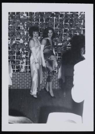 [Two brunettes in satin dresses, location unknown]
