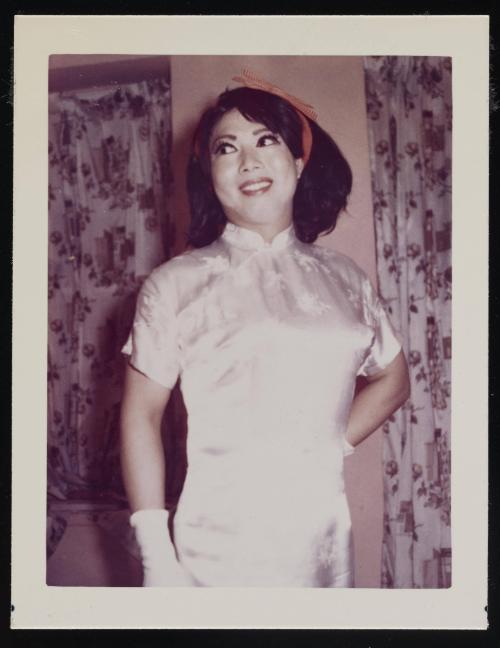 [Lili with a red ribbon, posing in front of floral curtains, location unknown]
