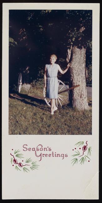 [Christmas card, Edith standing by wagon wheel, Casa Susanna, Hunter, NY]
