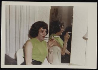 [Susanna smoking a cigarette by the mirror, location unknown]
