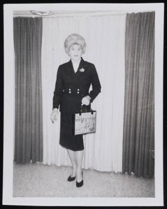 [Gloria at home in a dark suit with a handbag, Clarion, Michigan]
