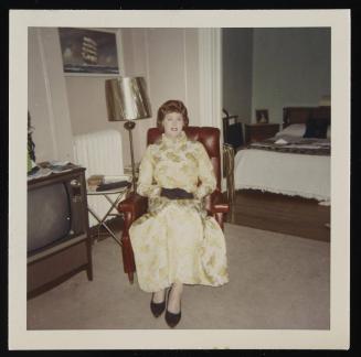 [In a gold and cream brocade dress, location unknown]
