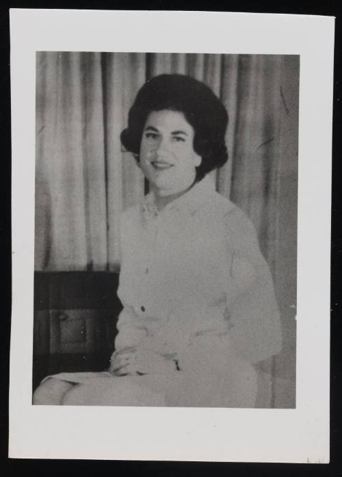 [Portrait of a brunette in white, location unknown]
