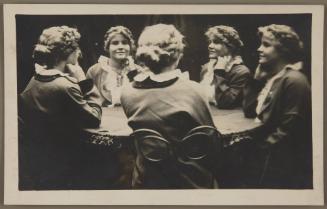 [Young woman with hand on chin]